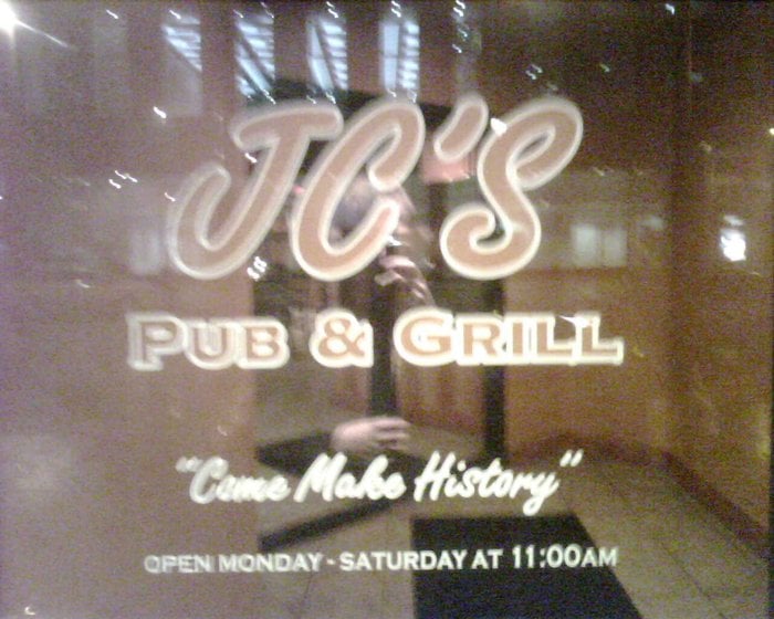 Sign on the entrance door of JC's Pub & Grill.